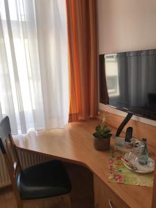 a wooden desk with a television on top of it at Hotel-Restaurant Kranefoer in Waltrop +7 photos