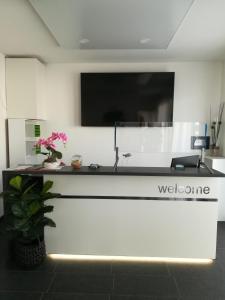 a reception desk with a television on a wall at Jura Hotel in Nürnberg