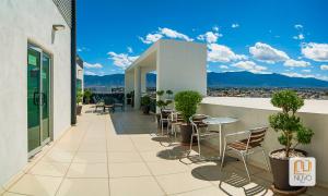 a balcony with chairs and tables on a building at Hotel Nuvo in Saltillo