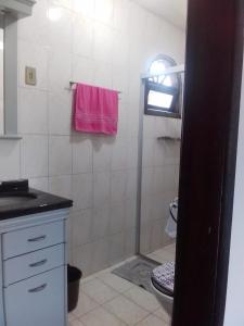 a bathroom with a toilet and a pink towel at Hostel e Pousada Boa Vista in Joinville