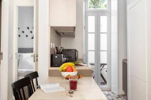 a kitchen with a table with a bowl of fruit on it at FLH Vila Rosário Cosy Flat I in Lisbon