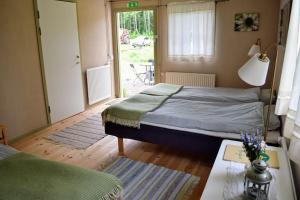 a bedroom with a bed and a table and a window at Ekologiska Fru Gran B&B i Tiveden in Gårdsjö