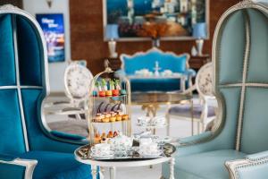 una stanza con sedie blu e un tavolo con dolci di Risemount Premier Resort Da Nang a Da Nang