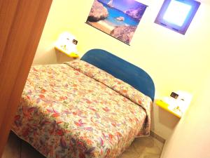 a small bedroom with a bed and a window at Villetta Tancau in Santa Maria Navarrese