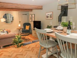 a kitchen and living room with a table and chairs at Overlea Cottage in Highpeak Junction