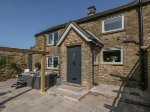 a brick house with a blue door at Overlea Cottage in Highpeak Junction