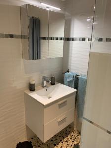 a white bathroom with a sink and a mirror at Les chambres de l'Archange in Frontenac