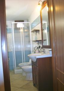 a bathroom with a toilet and a sink and a shower at Villetta Tancau in Santa Maria Navarrese