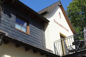 - un bâtiment avec un balcon sur le côté dans l'établissement Dreimädelhof, à Rüdesheim am Rhein