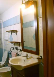 a bathroom with a sink and a mirror and a toilet at Villetta Tancau in Santa Maria Navarrese