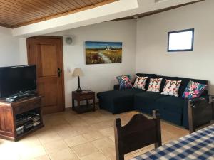 a living room with a couch and a flat screen tv at Windmill Hill in Cercal