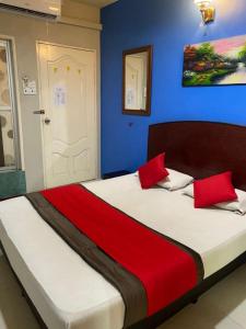 ein Schlafzimmer mit einem großen Bett mit roten Kissen in der Unterkunft Stada Hotel kubang kerian in Kota Bharu