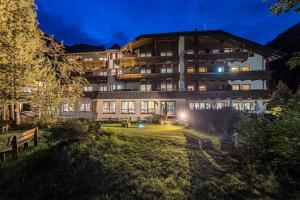 ein großes Gebäude mit Bänken davor in der Unterkunft Hotel Gletscherblick in Sankt Leonhard im Pitztal