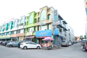 a street with cars parked in front of buildings at Stada Hotel kubang kerian in Kota Bharu