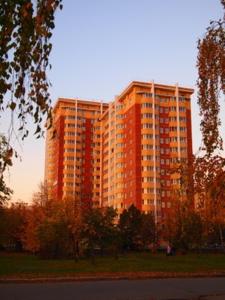 陶里亞蒂的住宿－KvartHaus on Revolutsionnaya，一座红色的大建筑,前面有树木