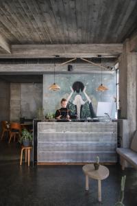 a man sitting at a desk in a room with a painting at IN Gallery Hotel & Spa in Korçë