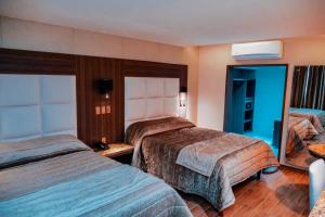 a hotel room with two beds and a mirror at KAVIA MEOQUI HOTEL & SUITES in Meoqui