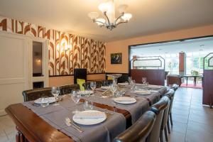 une salle à manger avec une grande table et des verres à vin dans l'établissement Auberge du port, à Bazeilles