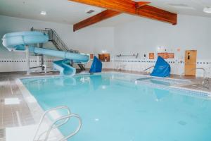 a large swimming pool with a slide in a room at Whitewater Inn in Big Sky