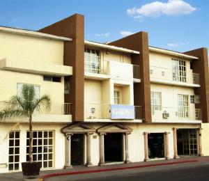 un grand bâtiment avec un palmier en face dans l'établissement Pequeno Gran Hotel, à Aguascalientes