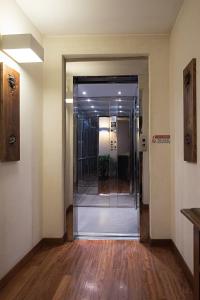 un couloir vide avec une porte en verre dans un bâtiment dans l'établissement Hotel Due Mori, à Vicence