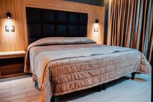 een slaapkamer met een groot bed met een zwart hoofdeinde bij KAVIA MEOQUI HOTEL & SUITES in Meoqui