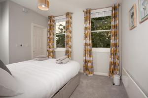 um quarto com uma cama e duas janelas em The Drawing Office em Berwick-Upon-Tweed