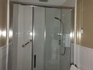 a shower with a glass door in a bathroom at Woodvale in Balloch