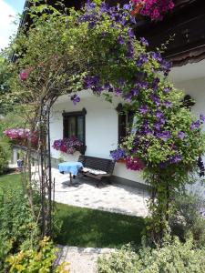 a garden with a bench and purple flowers at Gästehaus Verena in Mondsee