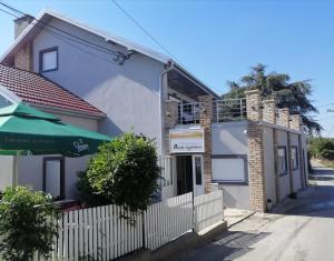 a house with a white fence and an umbrella at Vaš Kutak 2026 - Sobe Lux za izdavanje in Obrenovac