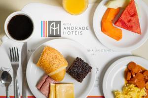 a table with three plates of food and a cup of coffee at Rede Andrade Riviera Premium in Salvador