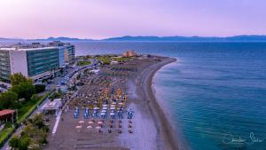 a beach with chairs and umbrellas and the ocean at Hotel Parthenon Rodos city in Rhodes Town