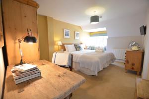 um quarto com 2 camas e uma mesa com um candeeiro em The Dolphin Inn em Thorpeness