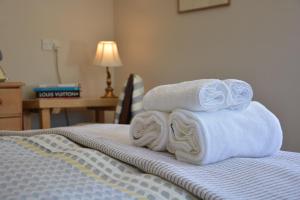 a pile of towels sitting on top of a bed at The Dolphin Inn in Thorpeness