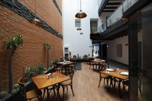 a restaurant with wooden tables and chairs and a brick wall at Hotel Diana in Puebla