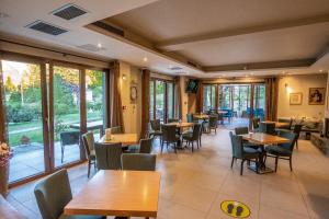 a restaurant with wooden tables and chairs and windows at Anavasi Mountain Resort in Pramanta