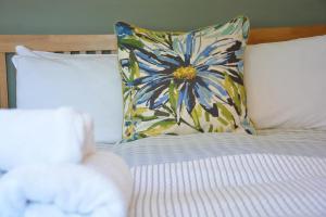 a bed with a flower pillow on top of it at The Dolphin Inn in Thorpeness