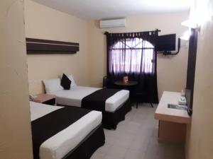 Habitación de hotel con 2 camas y ventana en Hotel Miramar Inn, en Ciudad Madero