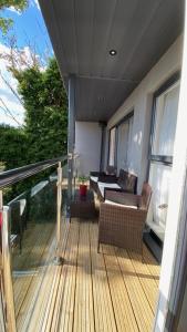 a deck with chairs and a couch on a balcony at Modern central flat with balcony & Free Parking on-site in Bournemouth