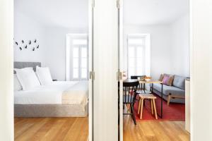 um quarto com uma cama e uma sala de estar em FLH Vila Rosário Cosy Flat II em Lisboa