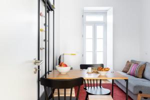 uma sala de estar com uma mesa e um sofá em FLH Vila Rosário Cosy Flat II em Lisboa