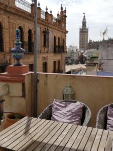 a table on a balcony with a view of a city at Duplex and terrace overlooking Giralda in Seville