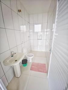 biała łazienka z umywalką i toaletą w obiekcie Pousada LM w mieście Nova América da Colina