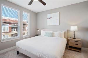 a bedroom with a white bed and two windows at Kasa Frisco Dallas in Frisco