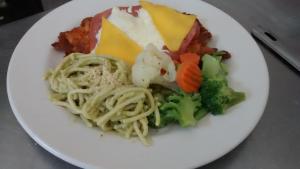 un plato blanco de comida con pasta y verduras en Hotel Miramar Inn en Ciudad Madero