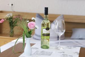 a bottle of wine and a vase with flowers on a table at Pension Hoffmann in Trebra