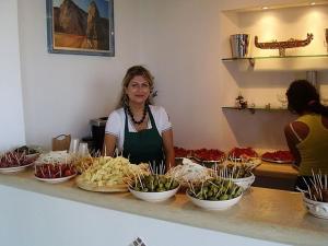 a woman standing behind a counter with bowls of food at Residence Chiesiola in Vieste