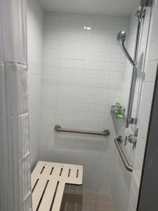 uma casa de banho com um chuveiro com um banco em Wyndham Garden Miami International Airport em Miami