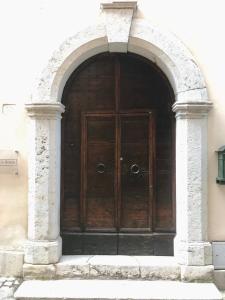 a large wooden door in a building with an arch at La Casa di Helena in Stroncone