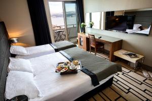 ein Hotelzimmer mit einem großen Bett und einem Tablett mit Essen darauf in der Unterkunft Cihangir Hotel in Istanbul